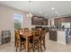 Dining room with wood table and chairs, open to kitchen at 3148 Marine Grass Dr, Wimauma, FL 33598
