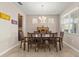 Dining room with a large window view, warm light fixture and dark wood accents, providing an inviting atmosphere at 3148 Marine Grass Dr, Wimauma, FL 33598