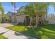 Two-story home featuring a three-car garage, brick accents, and a well-manicured lawn at 3148 Marine Grass Dr, Wimauma, FL 33598