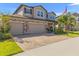 Two-story home featuring a three-car garage, brick accents, and a well-manicured lawn at 3148 Marine Grass Dr, Wimauma, FL 33598