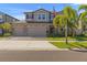Two-story home featuring a three-car garage, brick accents, and a well-manicured lawn at 3148 Marine Grass Dr, Wimauma, FL 33598