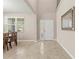 Bright foyer featuring tiled floors, a decorative window, and a white front door adjacent to the dining room at 3148 Marine Grass Dr, Wimauma, FL 33598