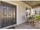 Cozy front porch with rocking chairs and a decorative front door at 3148 Marine Grass Dr, Wimauma, FL 33598
