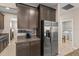 Kitchen with stainless steel refrigerator, dark cabinetry, and granite countertops, perfect for meal preparation at 3148 Marine Grass Dr, Wimauma, FL 33598