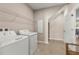 Bright laundry room featuring modern appliances, convenient storage, and neutral tile flooring at 3148 Marine Grass Dr, Wimauma, FL 33598