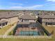 Aerial view of a screened-in pool with patio furniture and a white picket fence surrounding the backyard at 3148 Marine Grass Dr, Wimauma, FL 33598