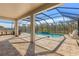 Covered pool area with outdoor kitchen and patio furniture, perfect for relaxation and entertaining at 3148 Marine Grass Dr, Wimauma, FL 33598