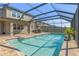 Inviting screened pool with a brick patio and built-in bar for outdoor entertaining at 3148 Marine Grass Dr, Wimauma, FL 33598