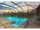 Enclosed screened pool area featuring tile floors and a view of the trees in the back at 3148 Marine Grass Dr, Wimauma, FL 33598