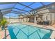 Relaxing screened pool features ample deck space, a bar area, and sunny views at 3148 Marine Grass Dr, Wimauma, FL 33598