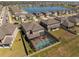 Aerial view of a screened-in pool and backyard with a lake view in a residential neighborhood at 3148 Marine Grass Dr, Wimauma, FL 33598