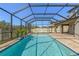 A refreshing screened pool with a small waterfall feature and a brick-paved patio at 3148 Marine Grass Dr, Wimauma, FL 33598