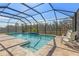 Inviting pool area with screened enclosure, stylish tiling, and poolside seating at 3148 Marine Grass Dr, Wimauma, FL 33598