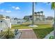 Beautifully landscaped backyard with white picket fence, leading to a canal and waterfront home at 3415 Croaker Dr, Hernando Beach, FL 34607