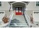 Close-up of a red front door with decorative glass, white railing, and manicured landscaping at 3415 Croaker Dr, Hernando Beach, FL 34607