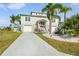 Charming two-story home with gray siding, red front door, palm trees and a well-maintained front yard at 3415 Croaker Dr, Hernando Beach, FL 34607