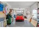 Organized garage featuring a vibrant red car and practical storage solutions for a clutter-free space at 3415 Croaker Dr, Hernando Beach, FL 34607