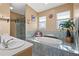 Main bathroom features tiled flooring, soaking tub, and glass-enclosed shower at 3415 Croaker Dr, Hernando Beach, FL 34607