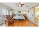 Bright main bedroom boasts hardwood floors, barn door to bathroom, and ceiling fan at 3415 Croaker Dr, Hernando Beach, FL 34607