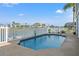 A refreshing pool area is enclosed by a fence with backyard landscaping and waterfront views at 3415 Croaker Dr, Hernando Beach, FL 34607