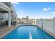 Inviting backyard pool area with fencing, outdoor seating, and stairs leading to a second-story deck at 3415 Croaker Dr, Hernando Beach, FL 34607