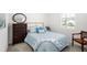 Cozy bedroom with neutral carpet, a metal bed frame, accent pillows and a window at 38602 Finn Clover Ln, Zephyrhills, FL 33540