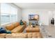 Inviting living room with large window, TV, and sectional couch at 38602 Finn Clover Ln, Zephyrhills, FL 33540
