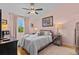Cozy pink bedroom featuring a queen bed, side tables, and a large window for natural light at 39650 Us Highway 19 N # 244, Tarpon Springs, FL 34689