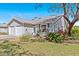Beautiful single-story house with a two-car garage surrounded by lush landscaping and mature trees at 39650 Us Highway 19 N # 244, Tarpon Springs, FL 34689