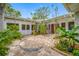 Charming courtyard with brickwork, tropical landscaping, and multiple access points for seamless indoor-outdoor living at 400 5Th S Ave, Safety Harbor, FL 34695