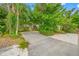 Long driveway lined with lush greenery leads to a home nestled in mature landscaping at 400 5Th S Ave, Safety Harbor, FL 34695