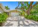 Exterior view featuring a home with a two-car garage, lovely landscaping, and pea gravel driveway at 400 5Th S Ave, Safety Harbor, FL 34695
