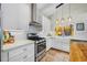 Kitchen with white cabinets, stainless steel appliances, and a farmhouse sink under the window at 400 5Th S Ave, Safety Harbor, FL 34695