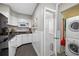 Efficient kitchen with white cabinets, dark countertops, and laundry area conveniently located nearby at 400 5Th S Ave, Safety Harbor, FL 34695