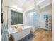 Beautiful main bathroom features soaking tub, glass shower and travertine floors at 400 5Th S Ave, Safety Harbor, FL 34695