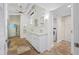 Bright main bathroom features a double vanity, travertine floors, and ensuite laundry at 400 5Th S Ave, Safety Harbor, FL 34695
