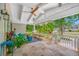 Inviting covered porch featuring travertine floors, a ceiling fan, and garden views at 400 5Th S Ave, Safety Harbor, FL 34695