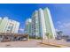 Contemporary condo building featuring covered parking and landscaped grounds against a clear blue sky at 400 64Th Ave # 1108, St Pete Beach, FL 33706