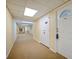 Long hallway features neutral carpet, lighting, doors and utility closet in a condominium building at 400 64Th Ave # 1108, St Pete Beach, FL 33706