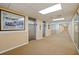 Hallway with beige walls leading to elevators features framed art and decorative lighting at 400 64Th Ave # 1108, St Pete Beach, FL 33706