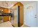 Galley kitchen features stainless steel refrigerator, wooden cabinets and tiled backsplash at 400 64Th Ave # 1108, St Pete Beach, FL 33706