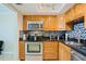 Well-equipped kitchen with wooden cabinets, stainless steel appliances, and stylish black countertops at 400 64Th Ave # 1108, St Pete Beach, FL 33706