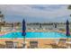 Outdoor pool with umbrellas and chairs and a view of the water at 400 64Th Ave # 1108, St Pete Beach, FL 33706