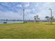 Scenic waterfront view with lush green lawn, community boat dock, and clear blue skies at 400 64Th Ave # 1108, St Pete Beach, FL 33706