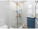 Bathroom features a glass shower with gold trim, unique tile, and a navy blue vanity at 4390 6Th Isle Dr, Hernando Beach, FL 34607