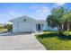 Charming single-story home features a light blue exterior, well-manicured lawn, and a one-car garage at 4390 6Th Isle Dr, Hernando Beach, FL 34607