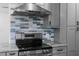 Modern kitchen showcases stainless steel appliances, gray cabinets, and a stylish blue backsplash at 4390 6Th Isle Dr, Hernando Beach, FL 34607
