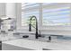 Bright kitchen featuring a farmhouse sink with a modern black faucet beneath window shutters at 4390 6Th Isle Dr, Hernando Beach, FL 34607