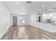 Bright, open-concept living room with modern wood-look floors, smooth white walls and kitchen access at 4390 6Th Isle Dr, Hernando Beach, FL 34607