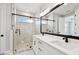 Bright bathroom with double vanity, framed mirrors, marbled floors, and a glass walk-in shower at 4717 W Mccoy St # 9, Tampa, FL 33616